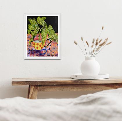 A small bright watercolour of lime green Lily leaves in a red spotted teacup on a flowered tablecloth