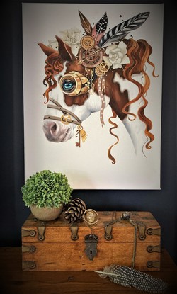 Pinto pony wearing an array of steampunk themed items, flowers, feathers, clocks, leather strapping with sprinkles of confetti styled sprays. All in the colour theme of browns, tans, blacks and whites