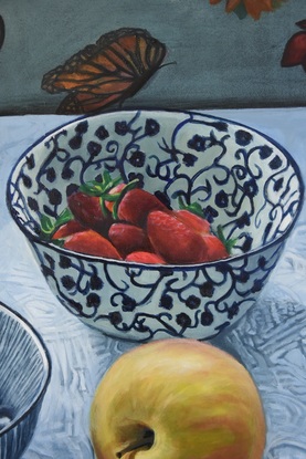 Bowls of berries, an apple, lemons, mandarin and silver oil jug on white tablecloth 
