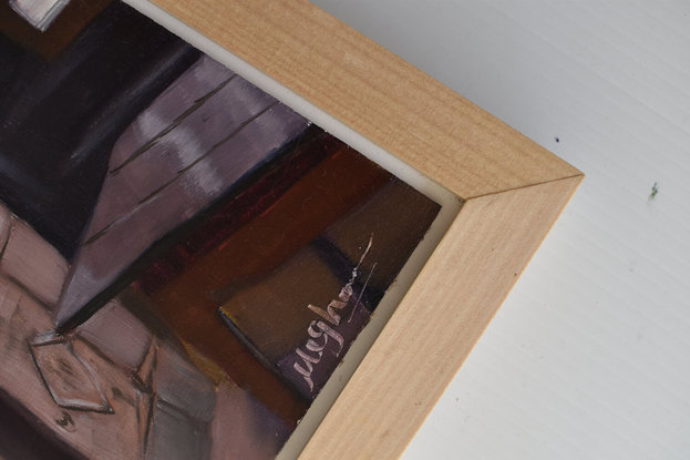 An old wooden kitchen cupboard in a corner beside a window that is bringing a ray of light casting shadows in the room.