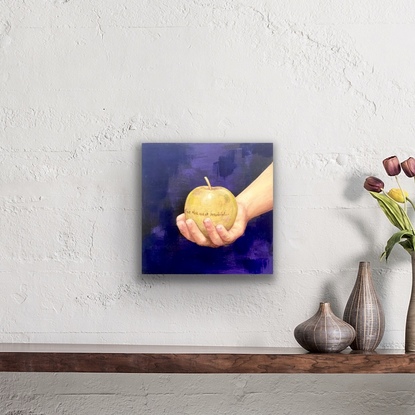 Youth's hand holding a gold apple inscribed with "for the most beautiful."