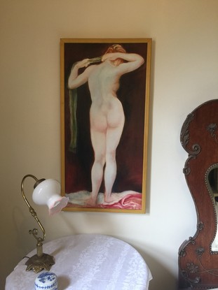 A full length standing female nude from a back view.