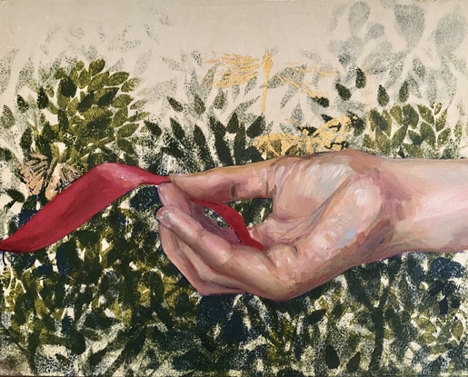 A woman's hand holding a red ribbon against a background of green foliage.