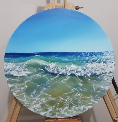 Turquoise and blue sea crashing into a wave on the shore of a beach. Oil paint on a round canvas.