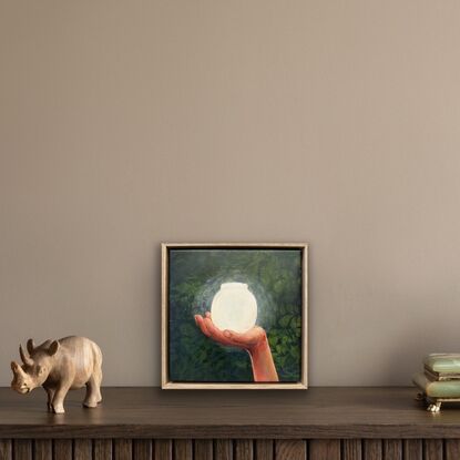 A hand holding a glowing jar in a dark forest.