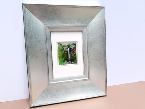 Miniature painting of a small waterfall viewed through a break in green forest; acrylic on stone tile by Victoria Collins.