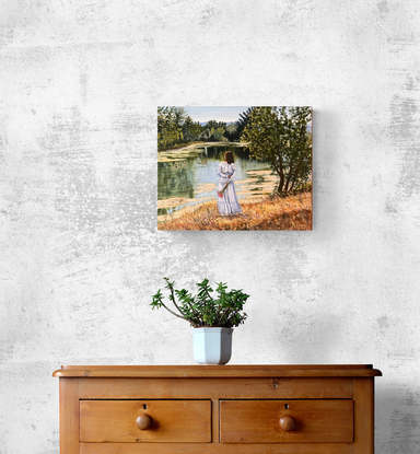 Woman in long dress standing on river bank looking at river reflections and ducks