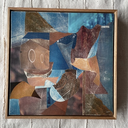 Square canvas board with paper collage in blues and browns blocks of colour in abstract shapes. 