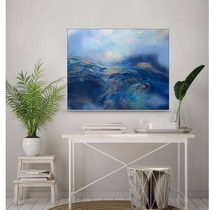 An atmospheric mountain and skies landscape painted in many shades of blue, highlighted in metallic soft gold and copper notes. It depicts the blue rolling mist over deep blue mountain ranges which meet the sky above