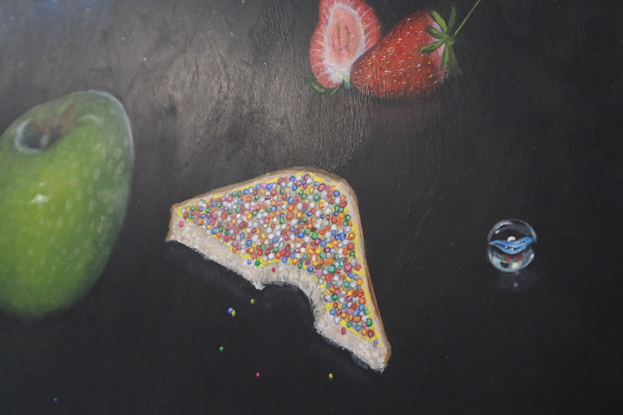 Painting of black night sky with band of the milky way in the upper third of the painting. In the foreground are cat eye marbles, a green granny smith apple, fairy bread with a bite taken out of it, a strawberry cut in half and another whole strawberry.