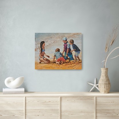 Family of children, brothers and sister, digging in the sand at the beach