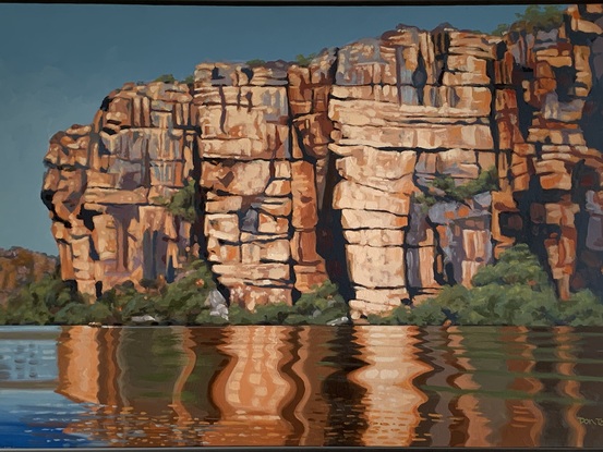 A large cliffs and water with reflections.