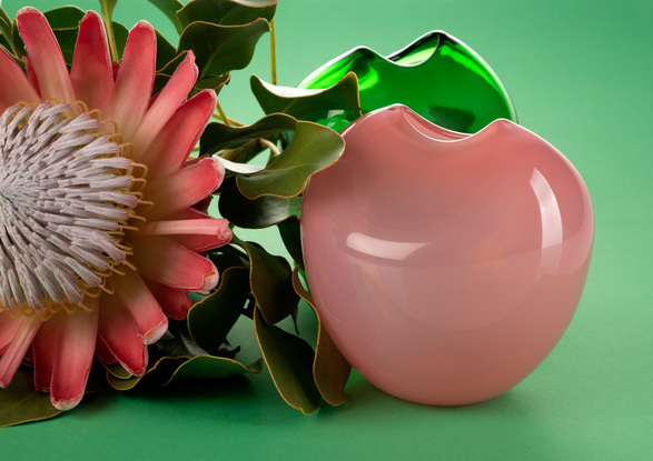 Round pink glass object with 'pinched' slot opening