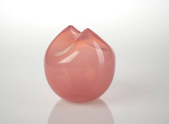 Round pink glass object with 'pinched' slot opening