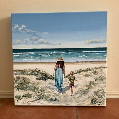 Woman and child walking through dunes to beach