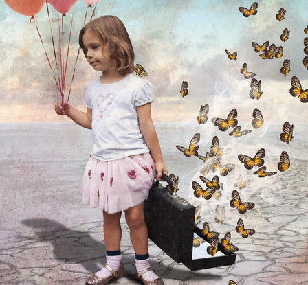 A little girl releases a suitcase full of butterflies into the wild blue yonder.