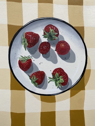 A yellow and white checked linen table cloth with a White and black plate on it with whole fresh strawberries scattered on that plate.