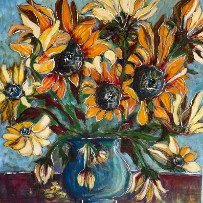 A large bunch of sunflowers in orange, yellows and deep blues, arranged in a vase, with an energetic feel about them.