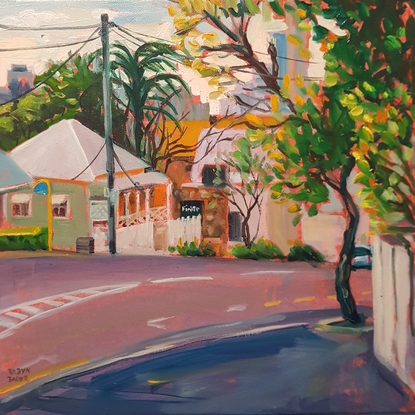 Street scene with bright morning light. Road and footpath with bright green leaves on the trees.