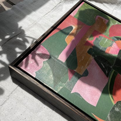 Square canvas board with paper collage in pink and green blocks of colour in abstract shapes. 