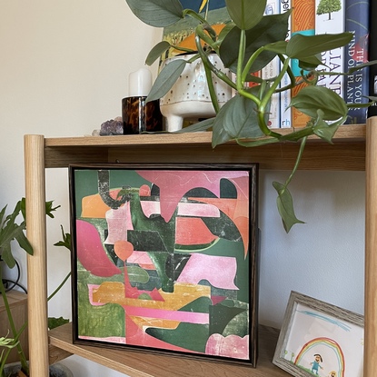 Square canvas board with paper collage in pink and green blocks of colour in abstract shapes. 