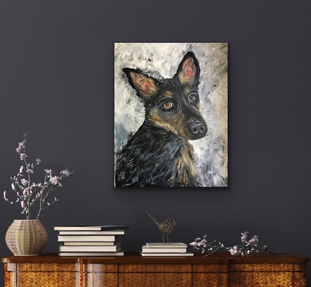 Torso of a black and tan kelpie dog on a textured grey background