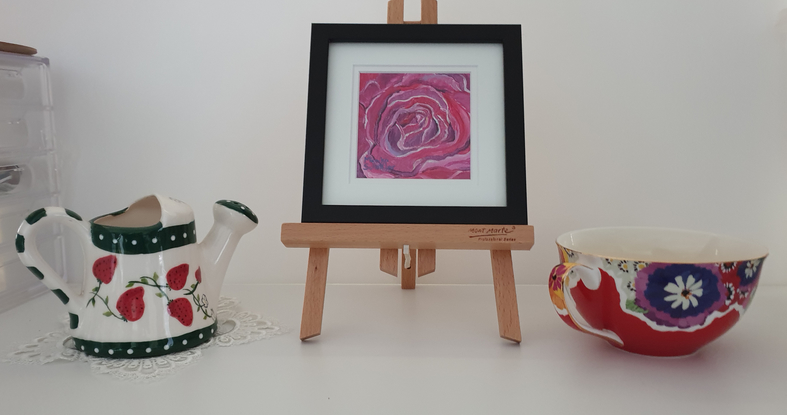 a macro look at the swirling petals of a crimson and red rose in bloom in miniature