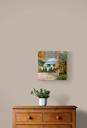 Woman and child looking at autumn leaves in front of a cottage