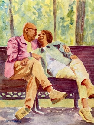 Couple sit on a bench in the park.