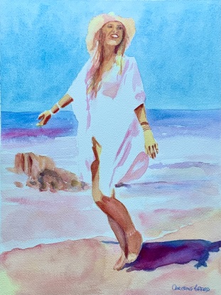 Woman standing on the beach in the sunshine.