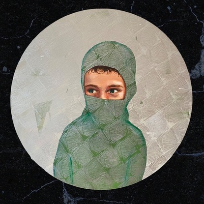 A portrait of a boy wearing a mask that reveals his green eyes.