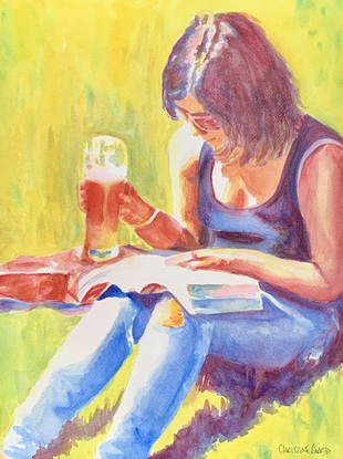 Woman sits enjoying a beer in the sunshine.