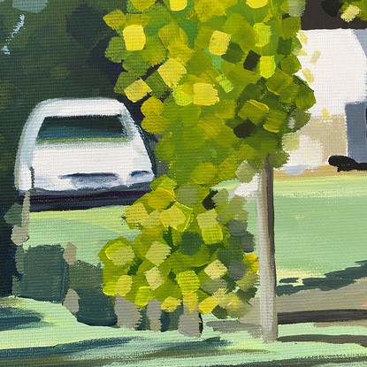 Country road with glimpse of white house and car behind large green trees and shadows on the road