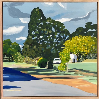 Country road with glimpse of white house and car behind large green trees and shadows on the road