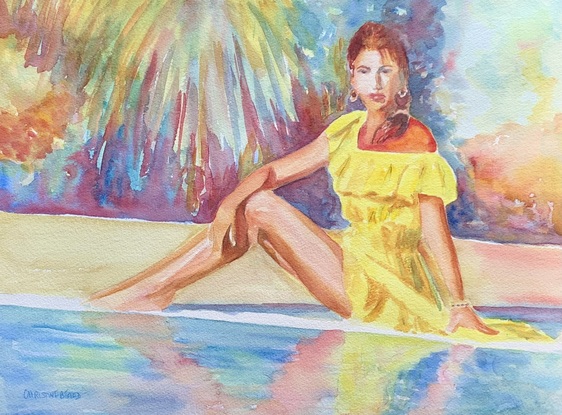 Woman sits by the pool in the sunshine.