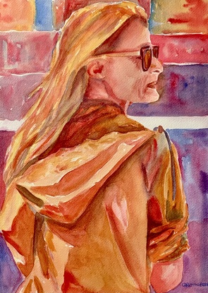 Woman standing wearing sunglasses in the sunshine.