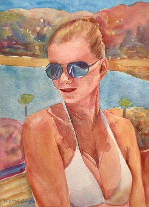 Woman sitting wearing sunglasses in the sunshine.