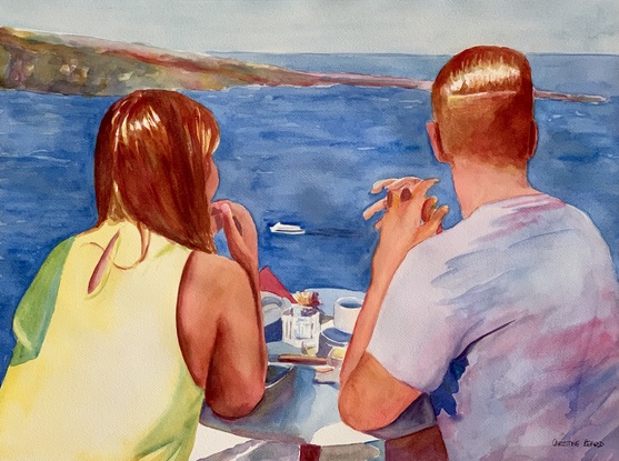 Couple take breakfast outside at a table with a  sea view.