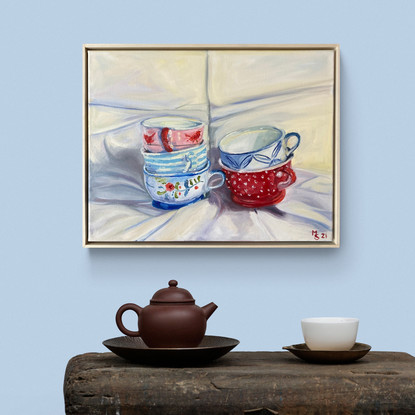 Two stacks of 3 colourfully designed teacups on white drapery