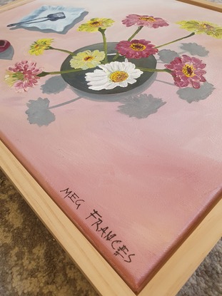 A birds-eye view of some Scenic Rim flowers in a round vase beside an antique blue plate and silver vintage sugar spoon.