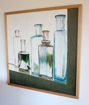 Five vintage bottles sitting on a window sill on a grey cold morning.