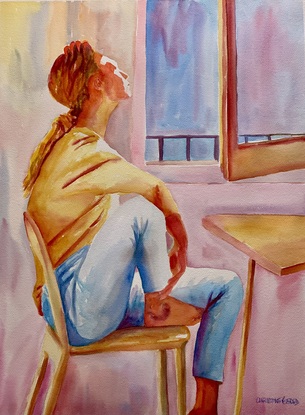 Woman sits by a window.