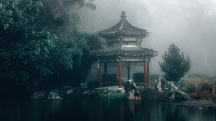 An earl morning foggy photograph of a temple with trees