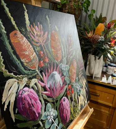 Proteas, banksias and gum leaves are gathered in a loose bunch. Painted with a black background with a hint of reflective light. 