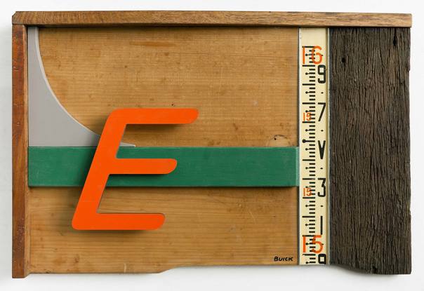 A three dimensional wall sculpture made of reclaimed timber and found objects. The colours in the work are natural wood and red and green. There is a large letter "E" in an orange/red and an aluminium section with a measurement scale on it.