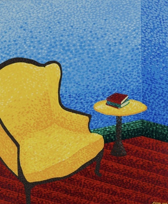 Yellow armchair in a blue room with a side table and books