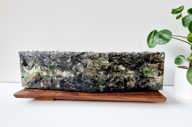 Recycled blown red, black, green and clear glass imbedded in bio resin with a sharp rough top showing  the texture of the glass.