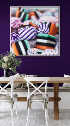 An orange and purple stripped  candy in a pile of multi coloured candies enlarges 1000 times real size. Dynamic photorealism artistry at its finest as it looks so real and pops off the wall

When one views closely, you can see how blur and rougher brush strokes come together for the illusion of realism.