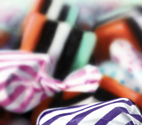 An orange and purple stripped  candy in a pile of multi coloured candies enlarges 1000 times real size. Dynamic photorealism artistry at its finest as it looks so real and pops off the wall

When one views closely, you can see how blur and rougher brush strokes come together for the illusion of realism.