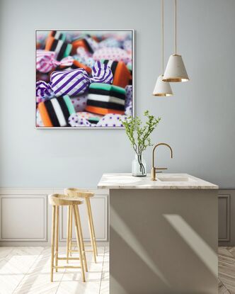 An orange and purple stripped  candy in a pile of multi coloured candies enlarges 1000 times real size. Dynamic photorealism artistry at its finest as it looks so real and pops off the wall

When one views closely, you can see how blur and rougher brush strokes come together for the illusion of realism.